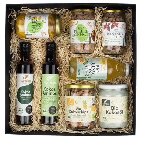 Kumaio Geschenkbox mit Bio-Produkten: Kokos Aminos Saucen, Bio Kokosöl, Bio Kokoschips, Bio Pulled Jackfruit, Bio Sweet Jackfruit, Bio Bananenblüten und Bio King Coconut Water – vegane Spezialitäten aus Sri Lanka, nachhaltig verpackt als Geschenkset.