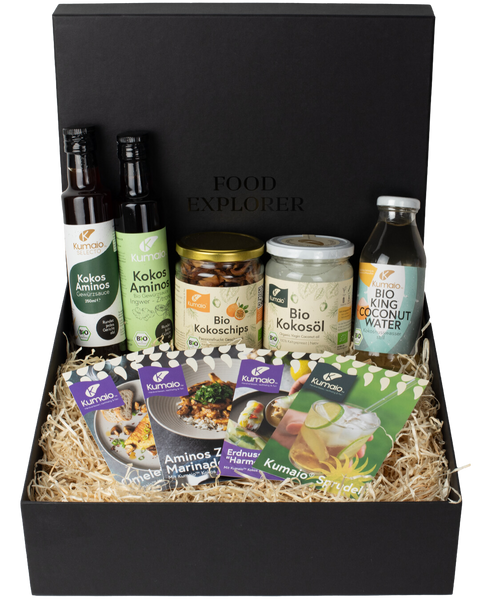 Schwarze Geschenkbox mit Kokosprodukten: Kokosöl, Kokoschips, Kokoswasser, Kokos-Aminos und Rezeptkarten von Kumaio.