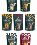 Kumaio® Bio Kokoschips in sieben Sorten als Set auf weißem Hintergrund: Natur, Ananas, Mango, Passionsfrucht, Zimt, Salt & Pepper und Sweet Chilli.