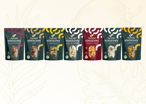 Kumaio® Bio Kokoschips Sortiment mit sieben Sorten: Passionsfrucht, Zimt, Ananas, Salt & Pepper, Sweet Chilli, Natur und Mango auf hellem Hintergrund mit dezenter Kokos-Illustration.