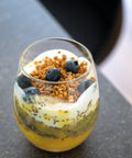 Schichtdessert im Glas mit Sweet Jackfruit, Chia, Joghurt, Granola und Blaubeeren.