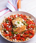 Peppadew rote Kirschpaprika-Streifen mit Fischfilet, weißen Bohnen, Oliven und Feta in Bulgur-Pfanne – mediterranes Hauptgericht.